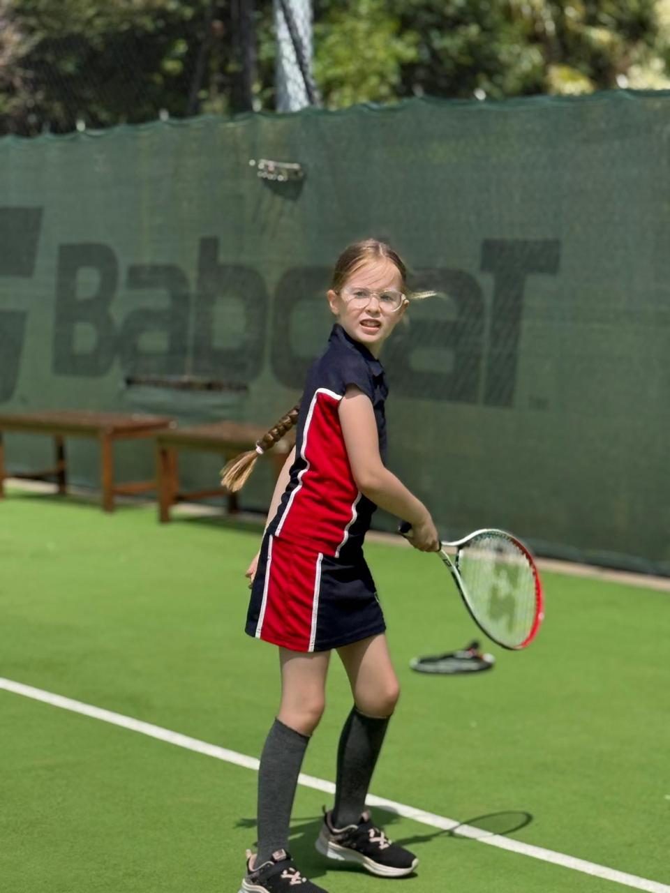 A pupil lines up a shot during a tennis lesson.