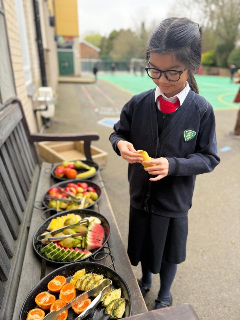 A child chooses fresh fruit at a healthy-eating stand.