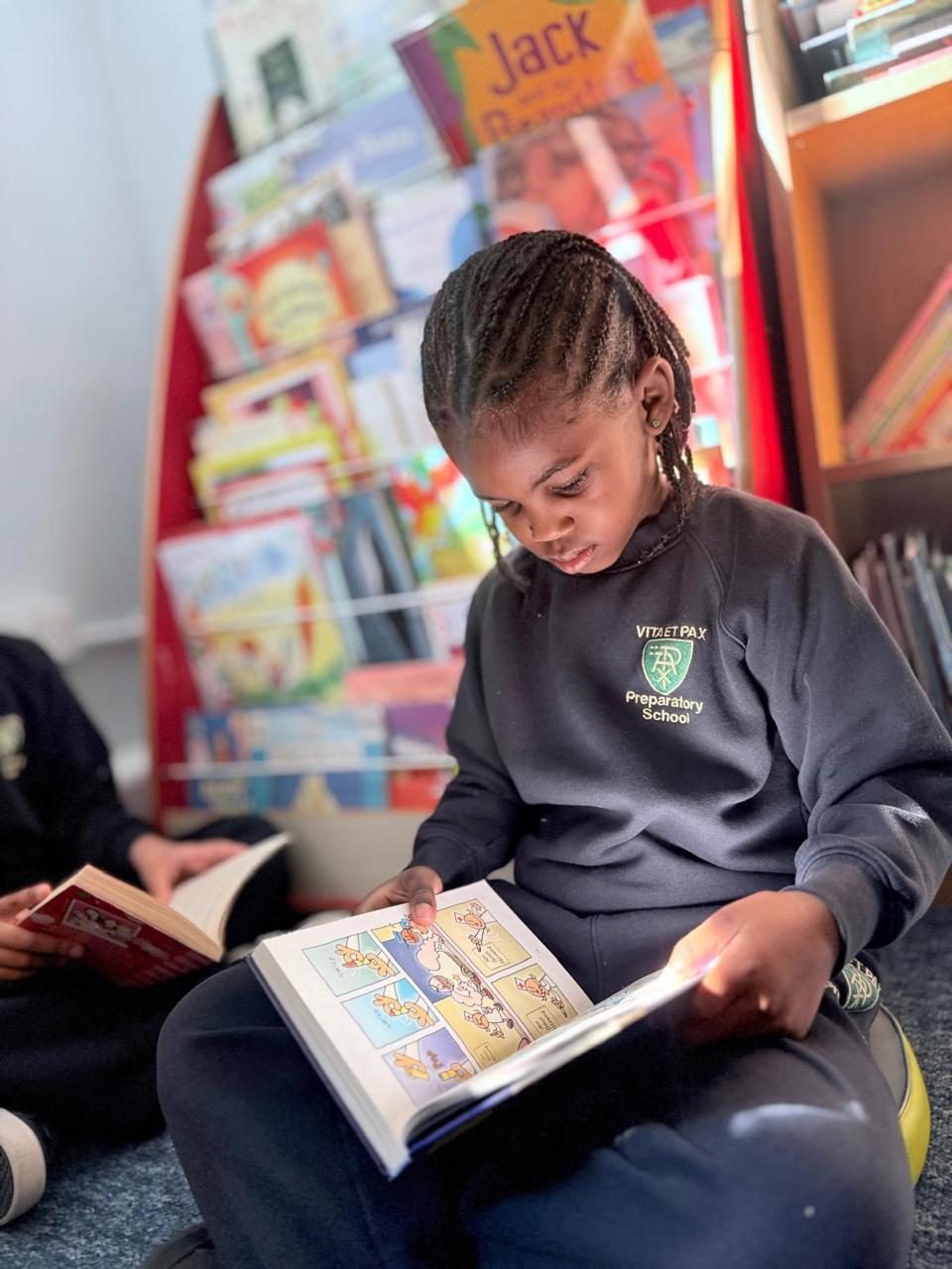 A child settles into the library with a favourite comic.