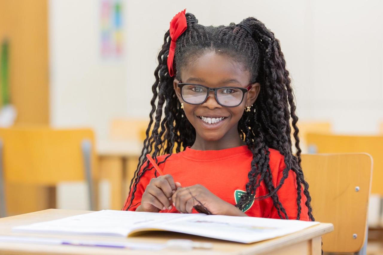 Smiling pupil working at a classroom desk