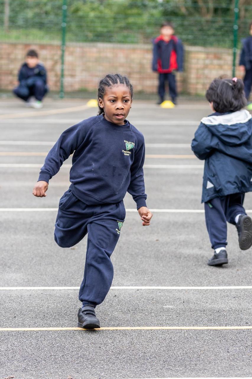 A pupil running on the playground during athletics at Vita et Pax