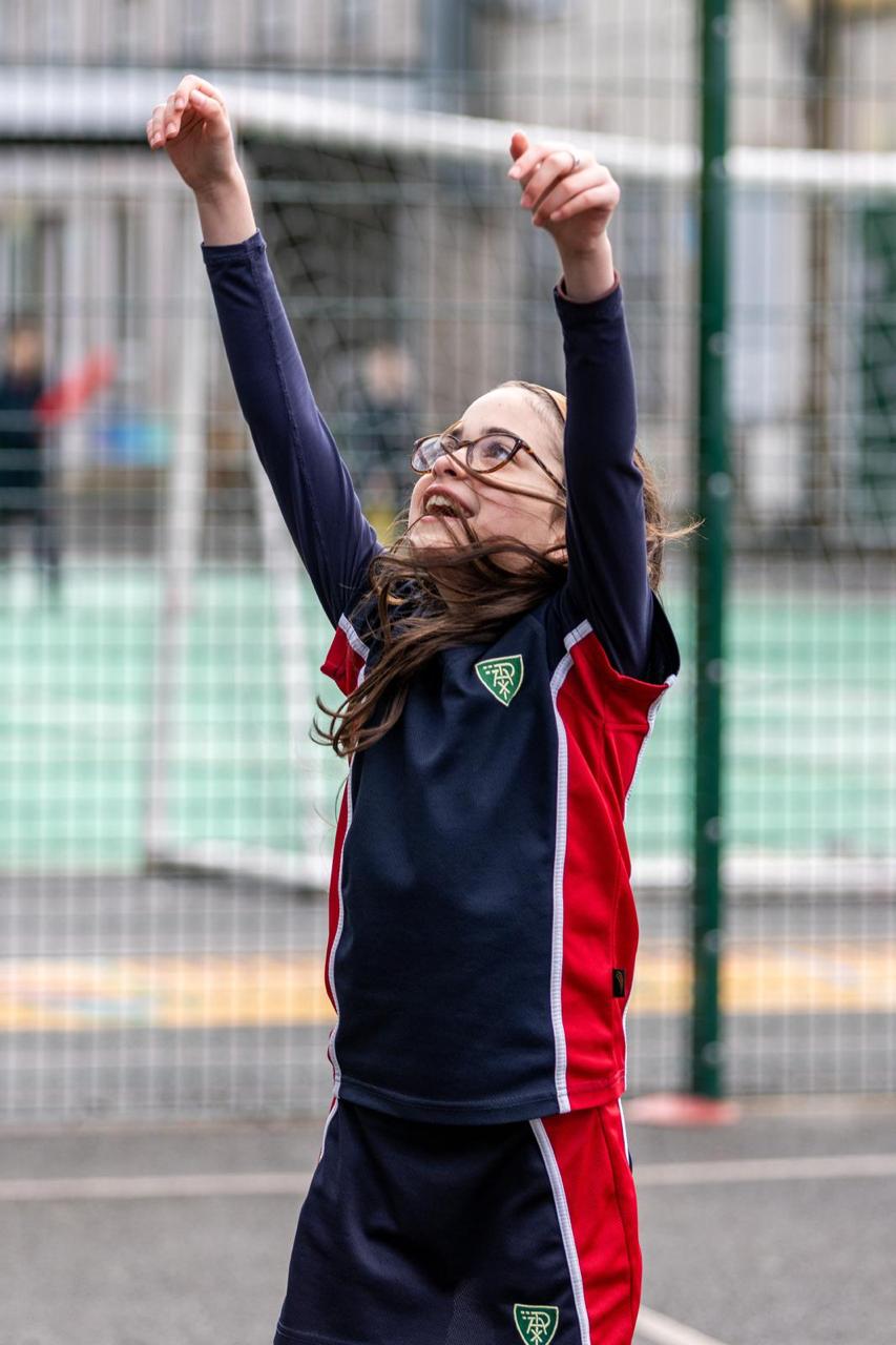 A pupil reaching for the ball in netball at Vita et Pax