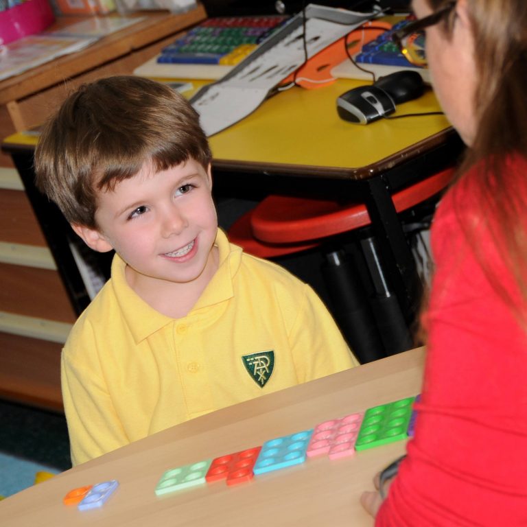 child smiling at the table, playing a game