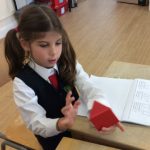 child using a red pyramid in a maths lesson