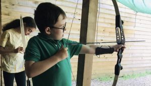 student with bow and arrow